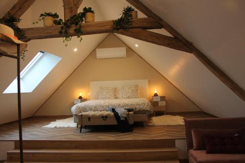een slaapkamer met een bed op de zolder bij Le Chainous in Pouillé