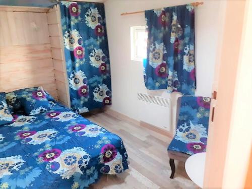 une chambre avec un lit et une chaise dans l'établissement Gîte des Flots de Ma Vie - Florence et Virginie Gossin - Barzan, à Barzan