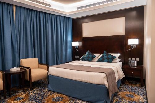 Mercure Jeddah Al Hamraa Hotel في جدة: غرفه فندقيه بسرير وكرسي