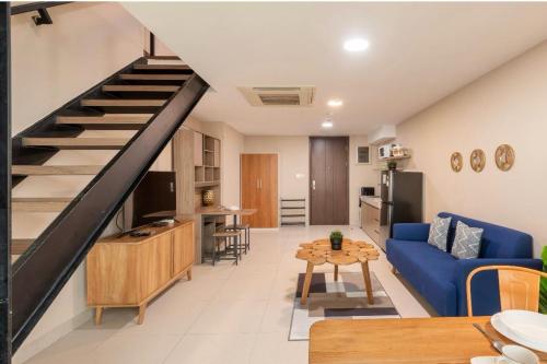 uma sala de estar com um sofá azul e uma escada em Time Suit Cozy loft with WiFi and pool em Klapadua