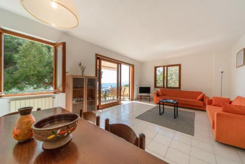 a living room with an orange couch and a table at Appartamenti Villa Innamorata in Capoliveri