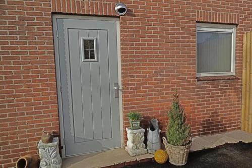 una porta per un edificio di mattoni con alcune piante accanto di B&B De BonAparte a Heemskerk