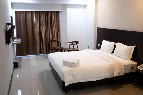 um quarto com uma cama grande e lençóis brancos em Kirei Inn em Nagoya