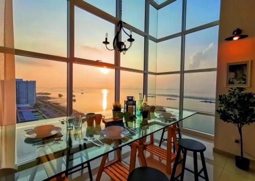 a glass dining room with a view of the ocean at Maritime Seaview Suites Penang in George Town