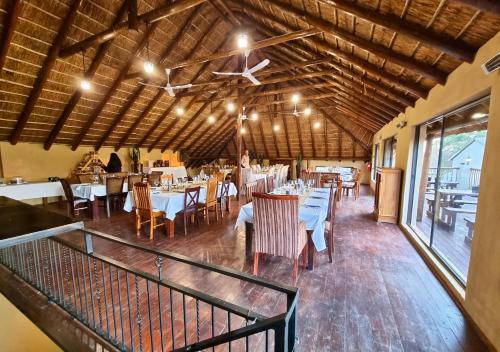 un restaurante con mesas y sillas en una habitación en Imbabali Retreat & Venue, en Magaliesburg
