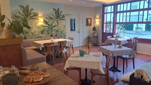un restaurant avec des tables et des chaises dans une salle dans l'établissement Boutique hôtel Maria-Christina, à Saint-Jean-de-Luz