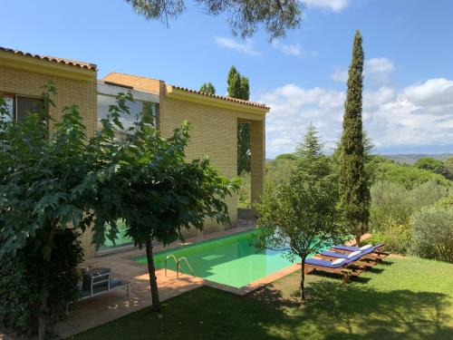 ein Haus mit einem Pool im Hof in der Unterkunft Architect Villa with Infinity Pool near Beach&Golf in Santa Cristina d'Aro