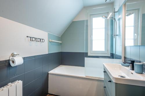 a bathroom with a sink and a tub and a mirror at Belle Dune in Fort-Mahon-Plage