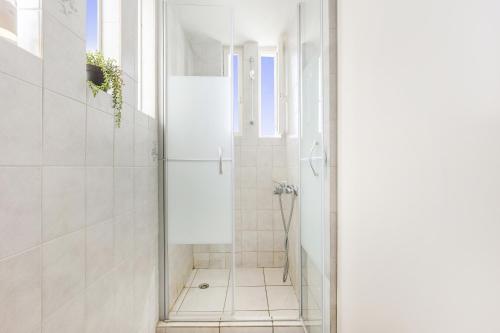 a white bathroom with a shower with a glass door at Porto Lina by GK Properties in Porto Rafti