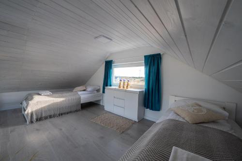a attic bedroom with two beds and a window at SunHouses in Darłowo