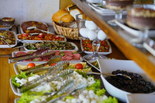un buffet avec de nombreuses assiettes de nourriture sur une table dans l'établissement Enjoy Stone Hotel, à Gorëme