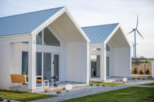 a white house with a blue roof at SunHouses - domki nad morzem in Darłowo