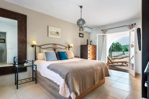 a bedroom with a bed and a door to a patio at Villa Can Truyet in Santa Eularia des Riu