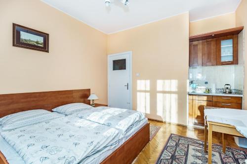 a bedroom with a large bed and a kitchen at Baltic Plaza Gdynia - MAXIMAL in Gdynia