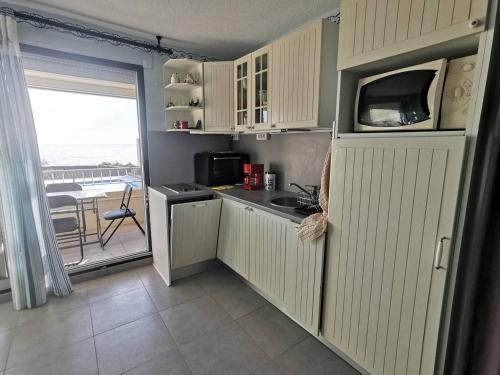 une petite cuisine avec un évier et un micro-ondes dans l'établissement 201 Indes Galantes A298, au Cap d'Agde