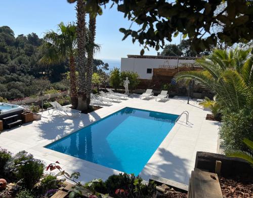 a swimming pool in a yard with palm trees at Casa KARIAN in Tossa de Mar