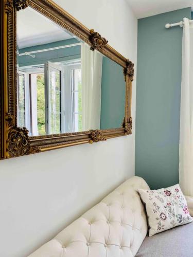 un miroir assis sur un mur à côté d'un canapé dans l'établissement Charmant studio dans Château du XXème, à Exincourt