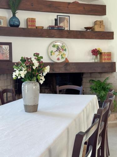 a table with a vase with flowers on it at Villa Mizar - Newly Renovated Private and an Amazing View in Torre delle Stelle