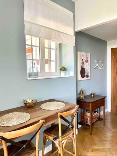 une salle à manger avec une table et des chaises en bois dans l'établissement Charmant studio dans Château du XXème, à Exincourt