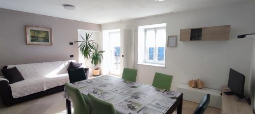 uma sala de estar com uma mesa e um sofá em Appartamento Alba em Folgaria