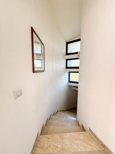 a staircase in a house with a picture on the wall at Villa Mizar - Newly Renovated Private and an Amazing View in Torre delle Stelle