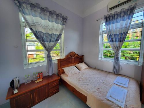 een slaapkamer met een bed en 2 ramen bij Vườn Quốc Gia U Minh Hạ in Xóm Mũi