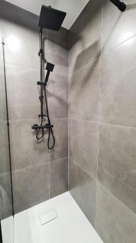 a bathroom with a shower with a light on the wall at Lokum z ogrodem in Płock