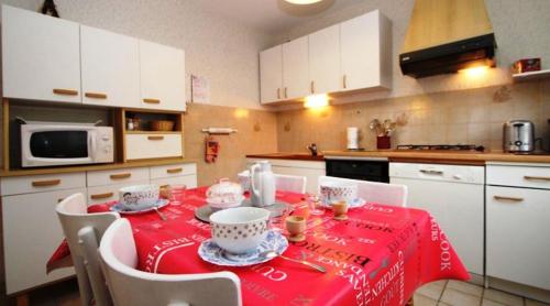 une cuisine avec une table et un chiffon rouge dans l'établissement LE GITE D'HENRI 1- Maison individuelle -3 chambres, à Chorges