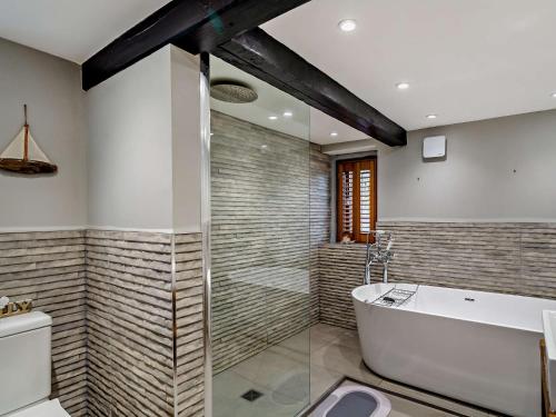 a bathroom with a bath tub and a toilet at 4 Bed in Marsden 94015 in Marsden