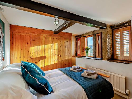 um quarto com uma cama grande e almofadas azuis em 4 Bed in Marsden 94015 em Marsden