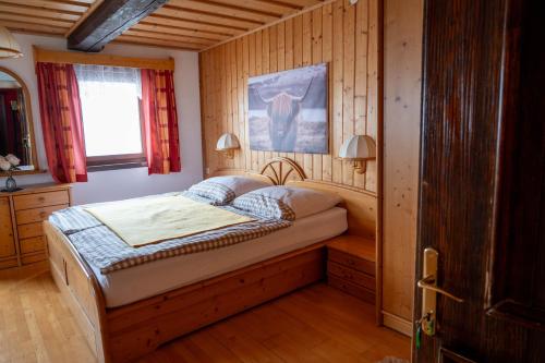ein Schlafzimmer mit einem Bett in einem Holzzimmer in der Unterkunft der Lamprechthof in Eisentratten