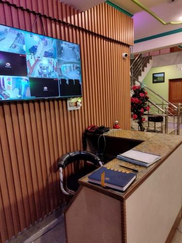 a room with a desk with a tv on a wall at Hotel Foothills , Srinagar in Srinagar