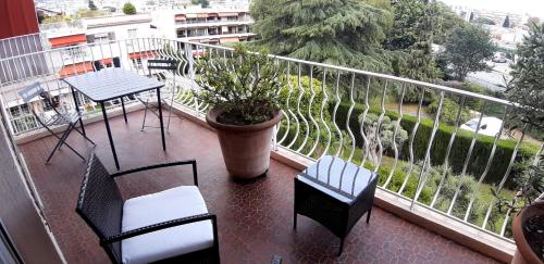d'un balcon avec des chaises et un pot avec une plante. dans l'établissement Vue mer-hippodrome à 2 pas de la mer et de la gare, à Cagnes-sur-Mer