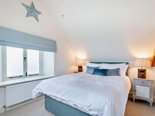 um quarto com uma cama grande e uma janela em 2 Bed in Cirencester 93878 em Coates