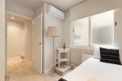 1 dormitorio con cama blanca y ventana en LetsGo Diagonal Avenue Apartment, en Barcelona