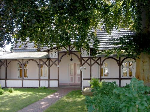 ein altes Haus mit einem Baum im Hof in der Unterkunft Alte Büdnerei - Apt 01 Erdgeschoss in Ostseebad Sellin