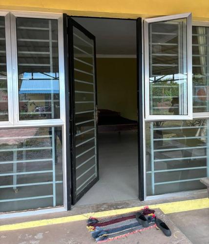 una puerta abierta a una habitación con ventanas y esquís en 2 Sisters Garden Bungalows, en Kampot