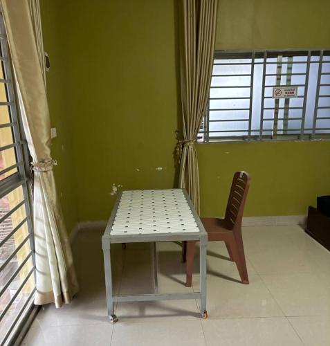 una mesa y una silla en una habitación con ventana en 2 Sisters Garden Bungalows, en Kampot