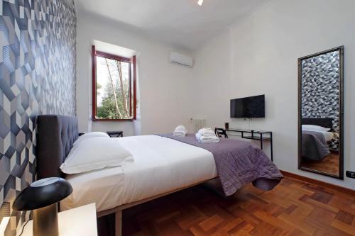 a bedroom with a large bed and a television at 4BNB - Donatello Apartment in Rome