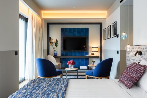 una camera d'albergo con letto, sedie e TV di Ara Maris a Sorrento