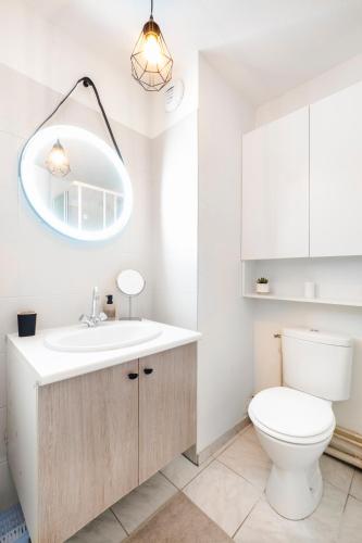 une salle de bain avec des toilettes blanches et un lavabo dans l'établissement Les Roses, Studio, à Pornichet