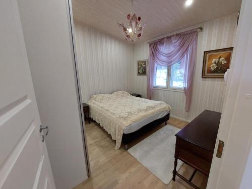 a bedroom with a bed and a window and a table at Tilava kaksio paritalosta in Kangasala