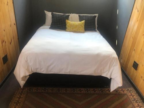 a large bed with white sheets and pillows on it at Hagedis Dorp - 1 Bedroom Apartment in Hartbeespoort