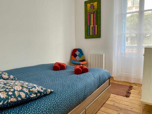 un dormitorio con una cama con animales de peluche rojos. en Mignon et cosy à côté de la mer, en Mers-les-Bains