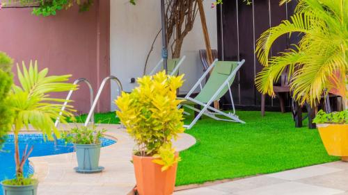 a patio with plants and a chair and a pool at L'Address in Cotonou