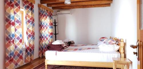 ein Schlafzimmer mit einem Bett mit einer farbenfrohen Wand in der Unterkunft Zabardast Guest House in Buxoro