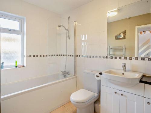 a white bathroom with a sink and a toilet and a tub at 2 Bed in Haverigg 94052 in Haverigg