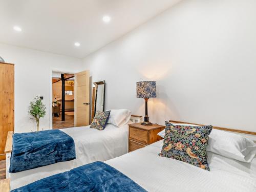 ein Schlafzimmer mit 2 Betten und einer Lampe auf einem Tisch in der Unterkunft 2 Bed in Buxton 94059 in New Mills