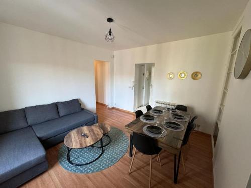 un salon avec un canapé bleu et une table dans l'établissement Le spacieux, au Havre