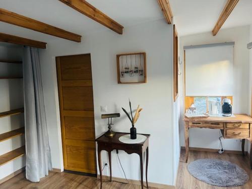Pokój z drzwiami, stołem i biurkiem w obiekcie Chambre Chalet de Thau w mieście Balaruc-le-Vieux